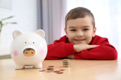 Photo of Little boy with piggy bank and money at home, closeup