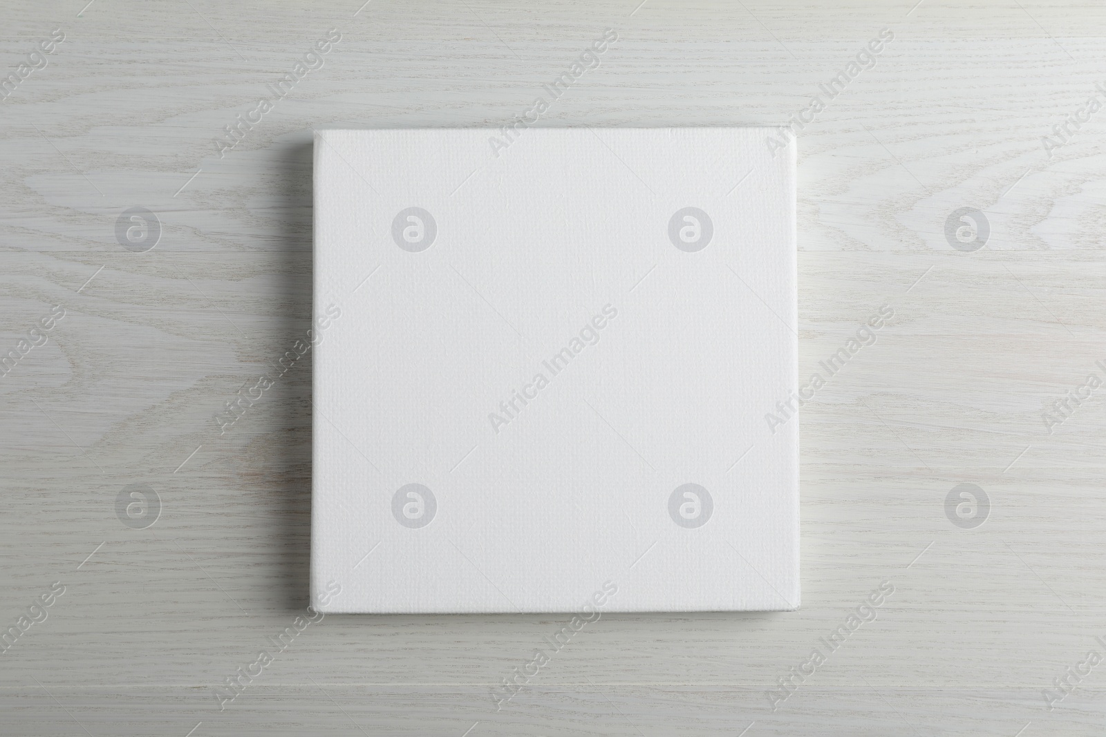 Photo of Blank canvas on white wooden background, space for text