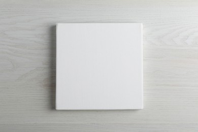 Photo of Blank canvas on white wooden background, space for text