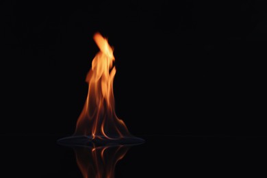 Photo of Beautiful view of flaming vodka on black background