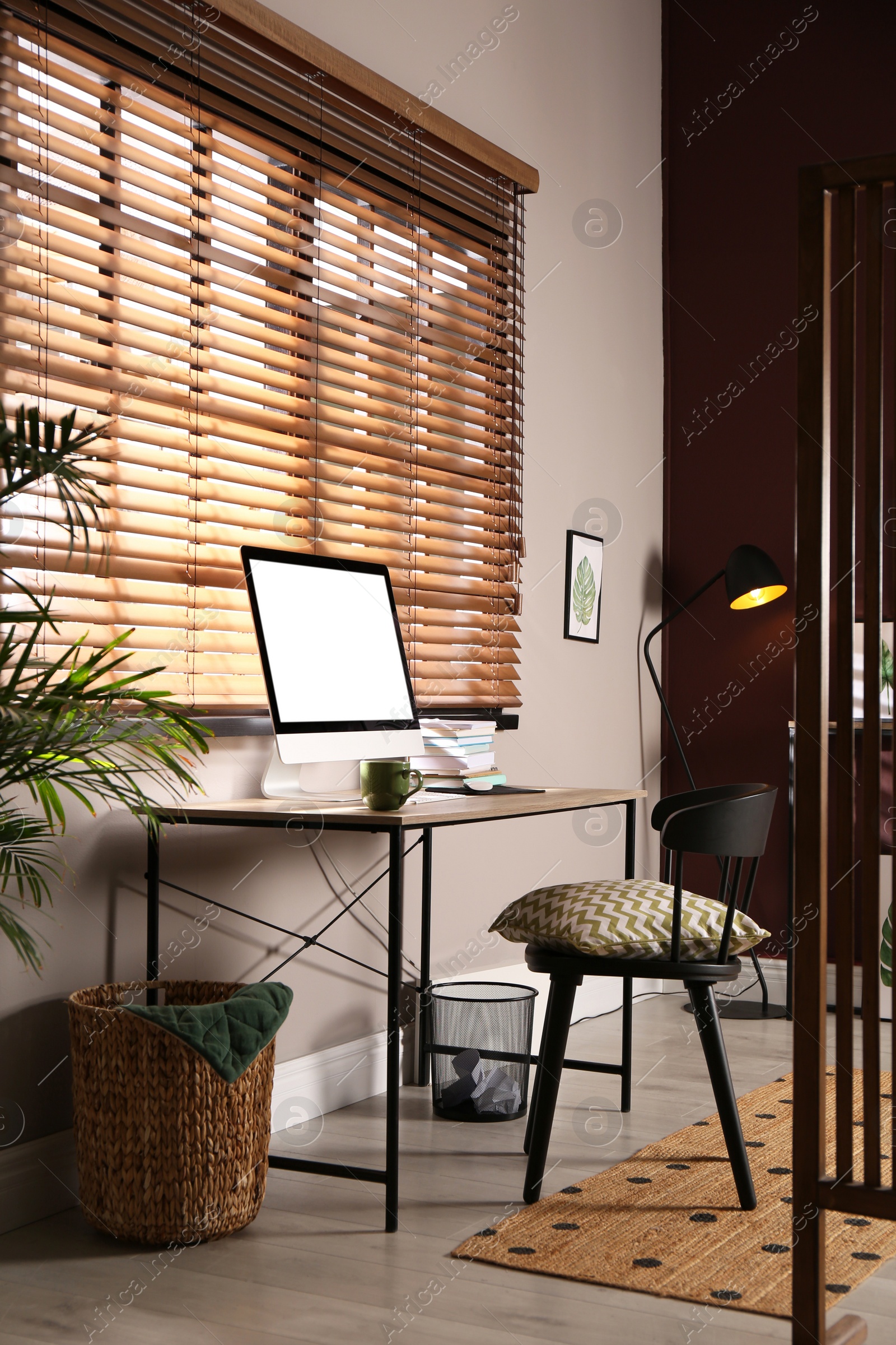 Photo of Comfortable workplace with modern computer and stylish furniture in room. Interior design