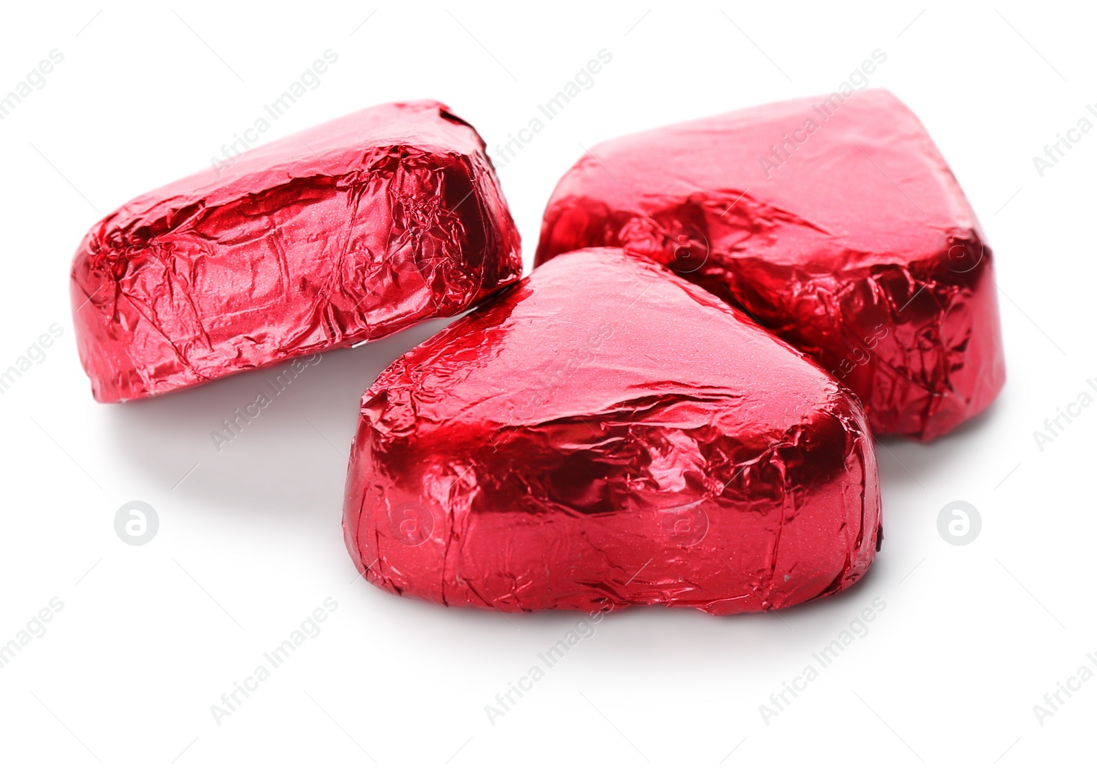 Photo of Heart shaped chocolate candies in red foil on white background