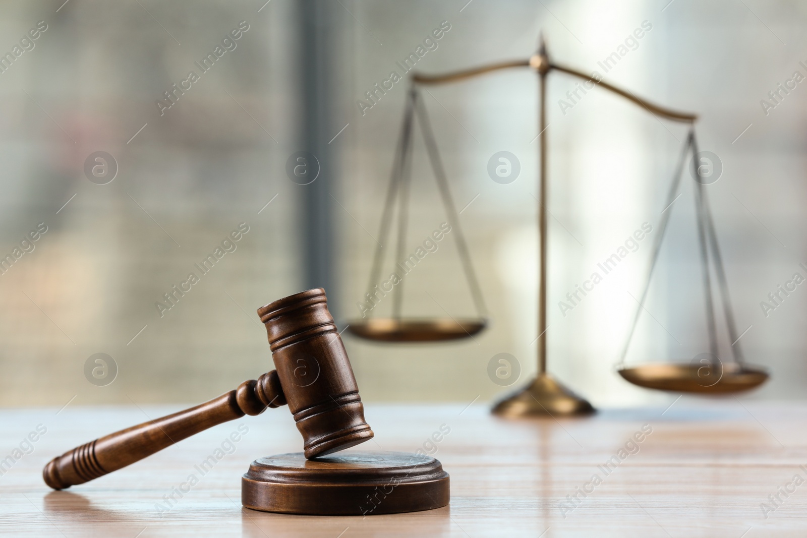 Photo of Wooden gavel and scales of justice on table indoors. Space for text