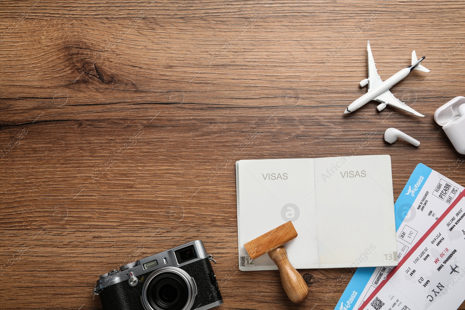 Photo of Flat lay composition with passport, stamp and flight tickets on wooden table, space for text