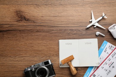 Flat lay composition with passport, stamp and flight tickets on wooden table, space for text