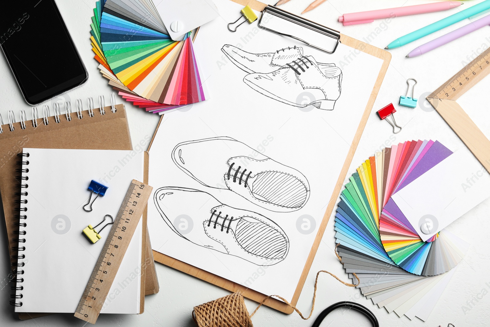 Photo of Flat lay composition with drawing of shoes on white table. Designer's workplace