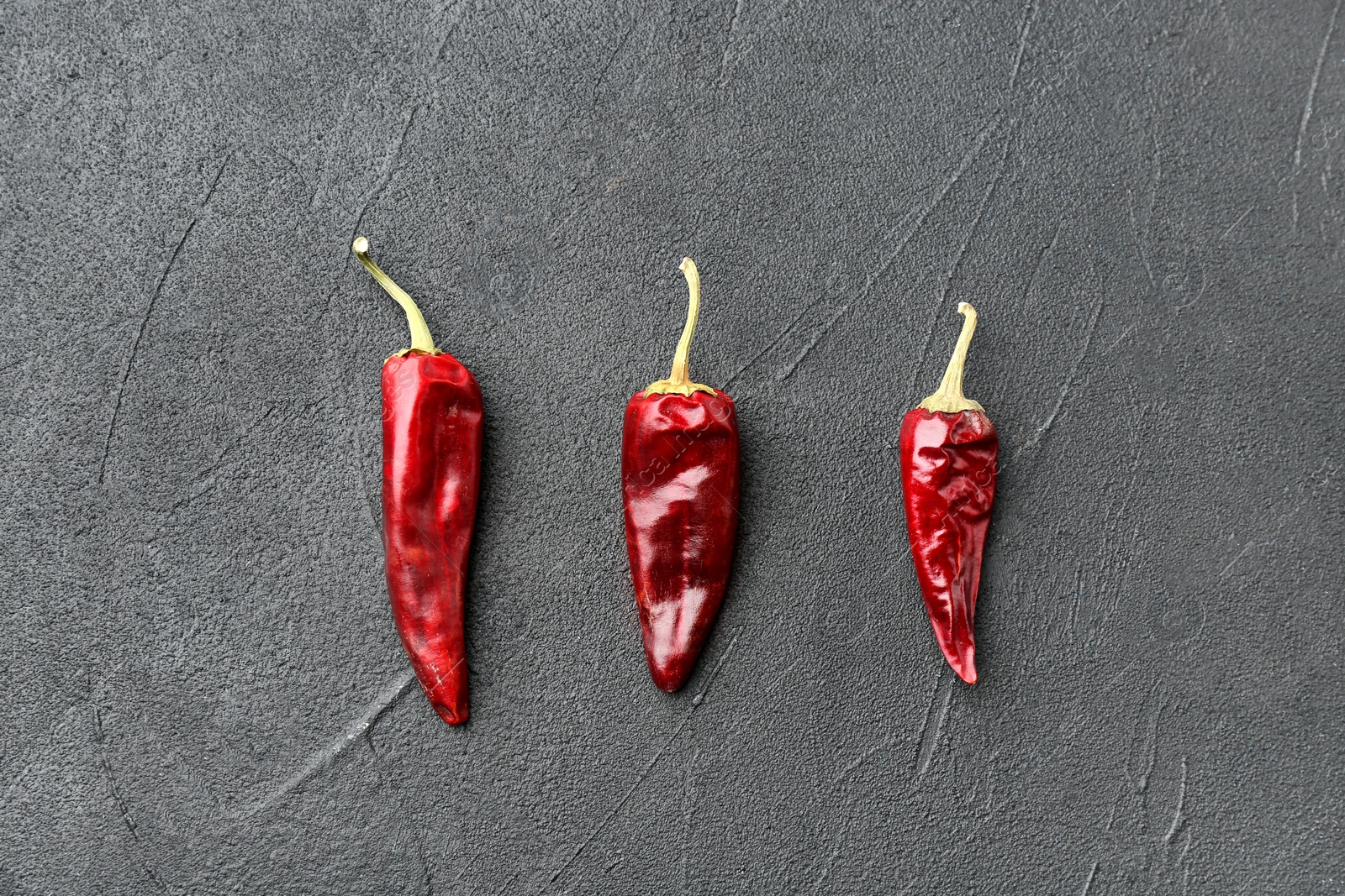 Photo of Dry chili peppers on grey background, top view