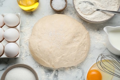 Fresh yeast dough and ingredients on white marble table, flat lay