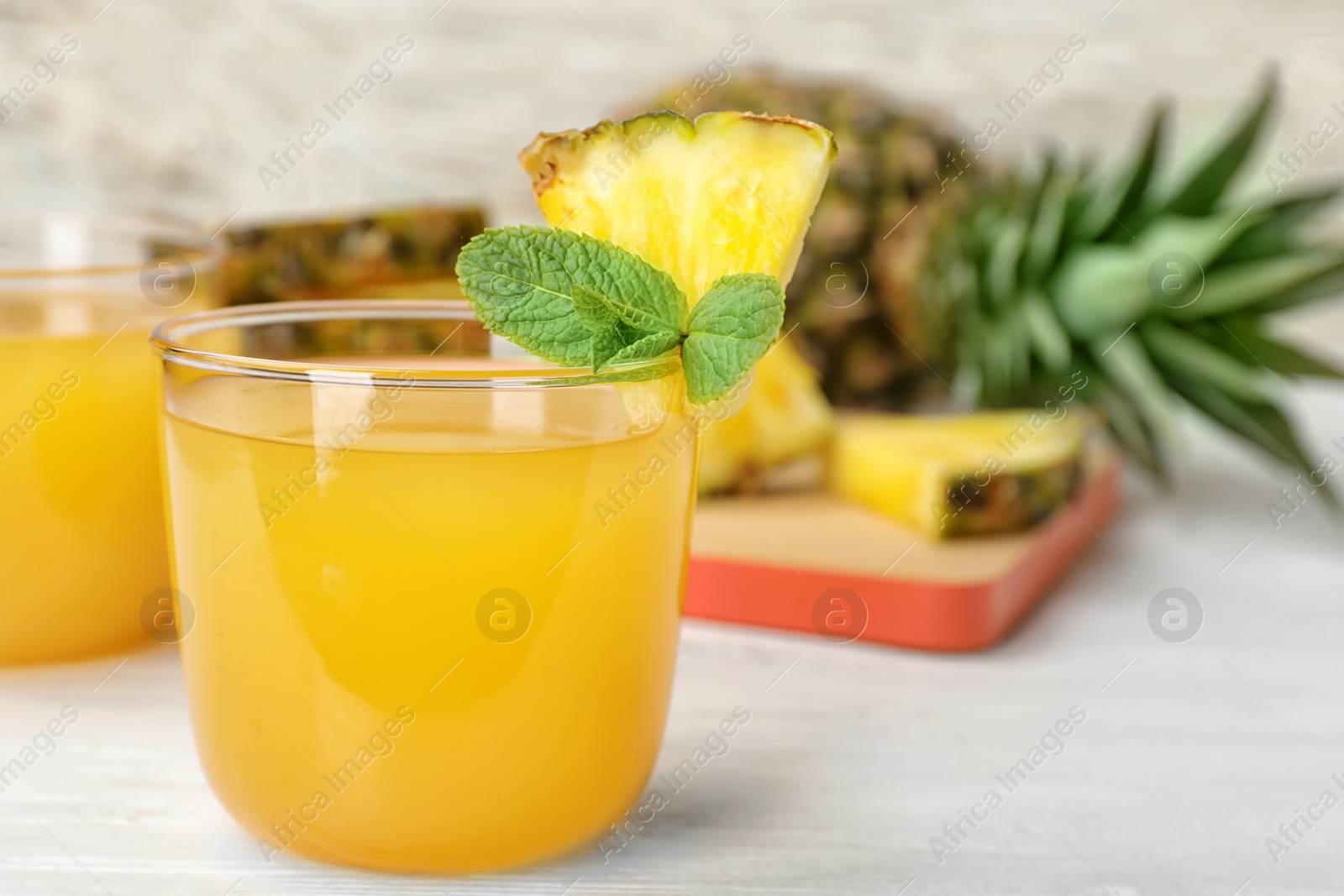 Photo of Glass with delicious pineapple juice on table