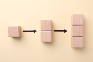 Photo of Business process organization and optimization. Scheme with wooden figures and arrows on beige background, top view