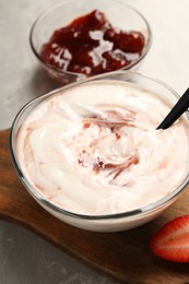 Tasty yoghurt with jam and strawberry on grey table, closeup