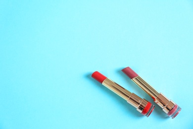 Photo of Flat lay composition with different stylish lipsticks on color background, space for text