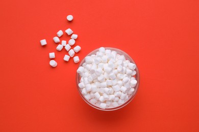Photo of Bowl with delicious marshmallows on red background, flat lay
