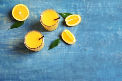 Jars of orange juice and fresh fruits on table, top view