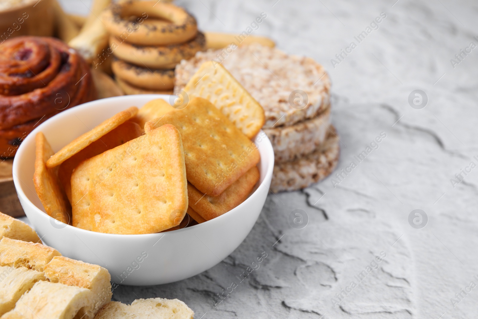 Photo of Different gluten free products on light grey textured table, closeup. Space for text