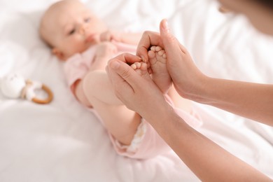 Photo of Mother with her cute little baby on white sheets, selective focus