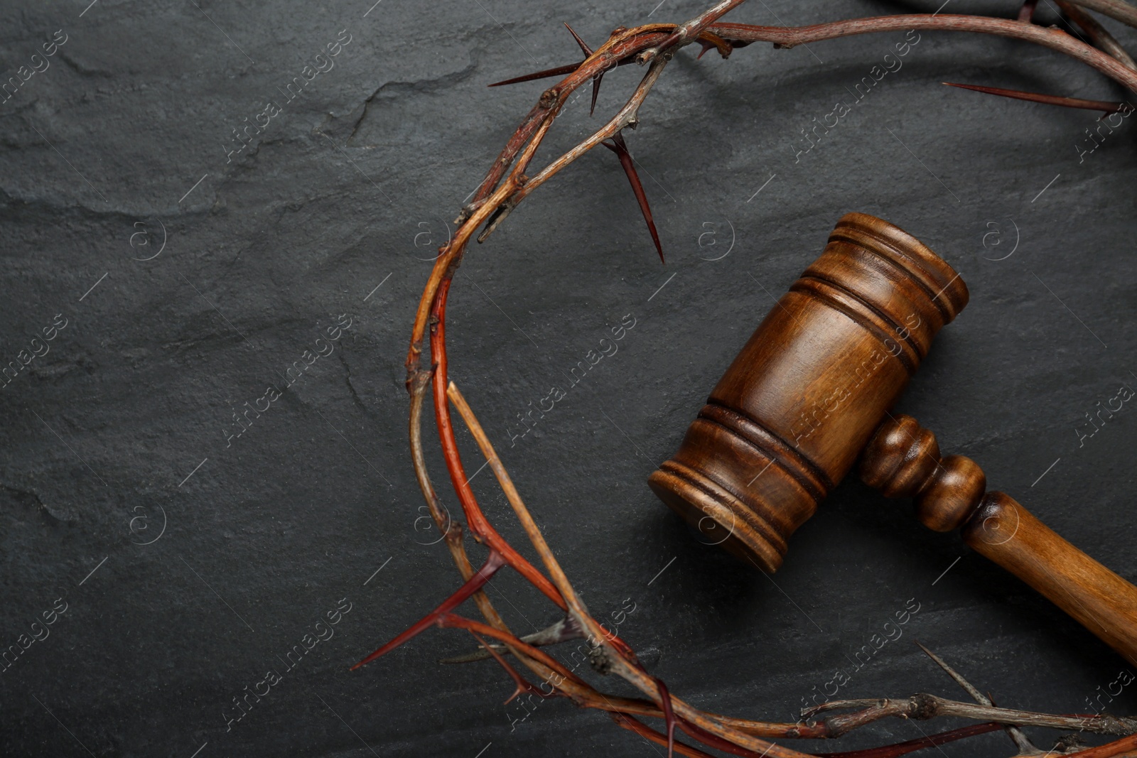 Photo of Crown of thorns and judge gavel on black table, flat lay. Space for text