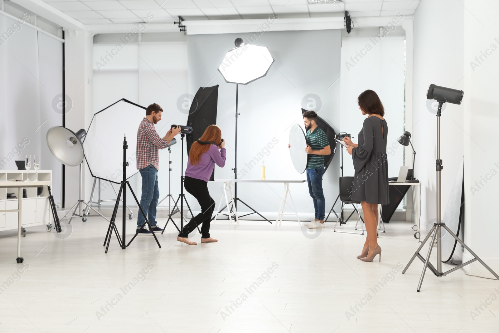 Photo of Photo studio with professional equipment and team of workers