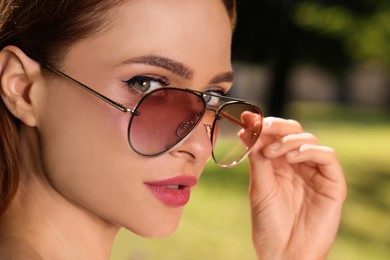 Photo of Beautiful woman in sunglasses outdoors on sunny day, closeup