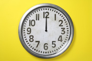 Photo of Modern clock on yellow background, top view