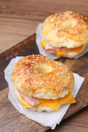 Photo of Delicious bagels with ham and cheese on table, closeup