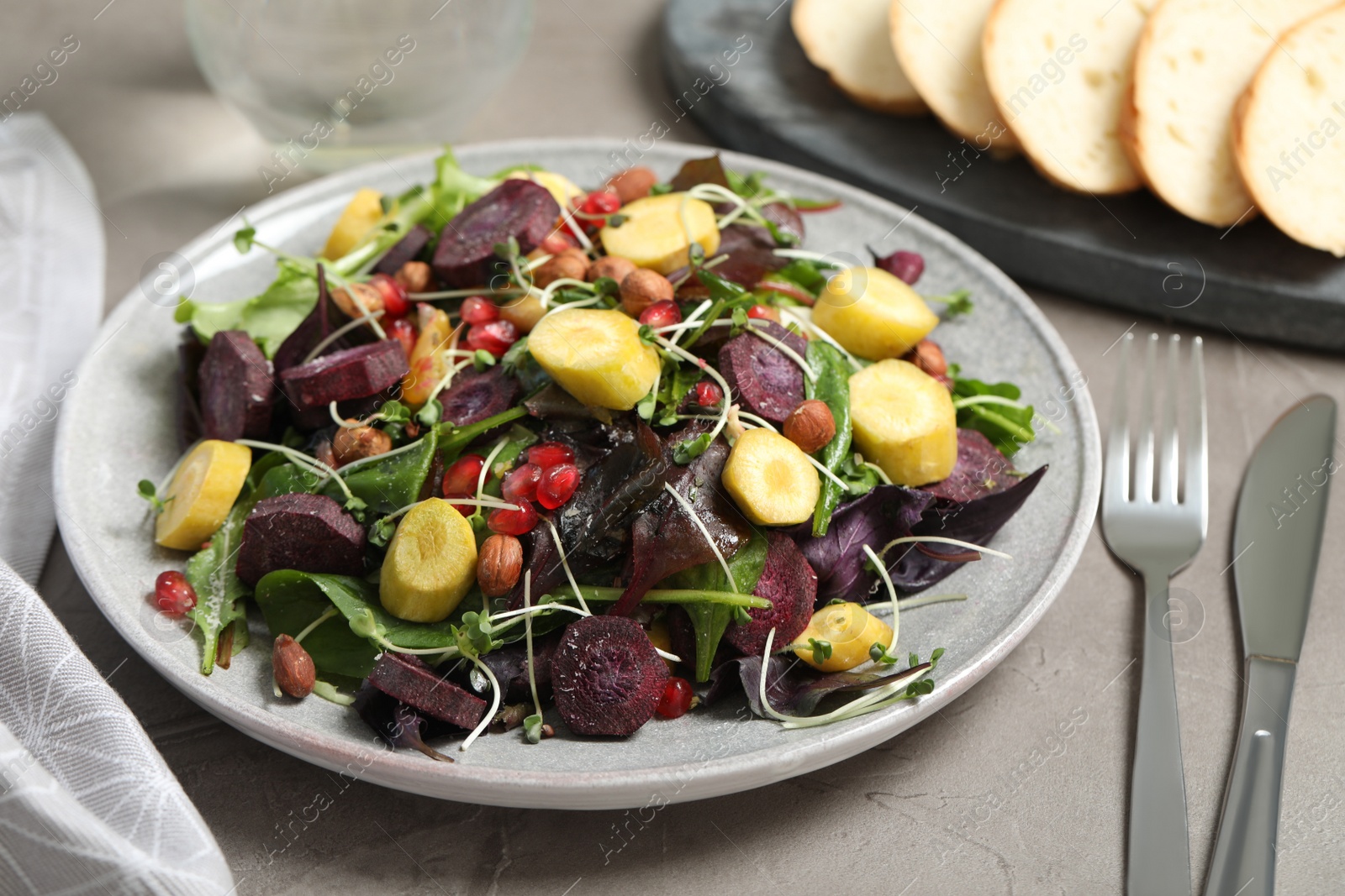 Photo of Delicious fresh carrot salad served on grey table, closeup