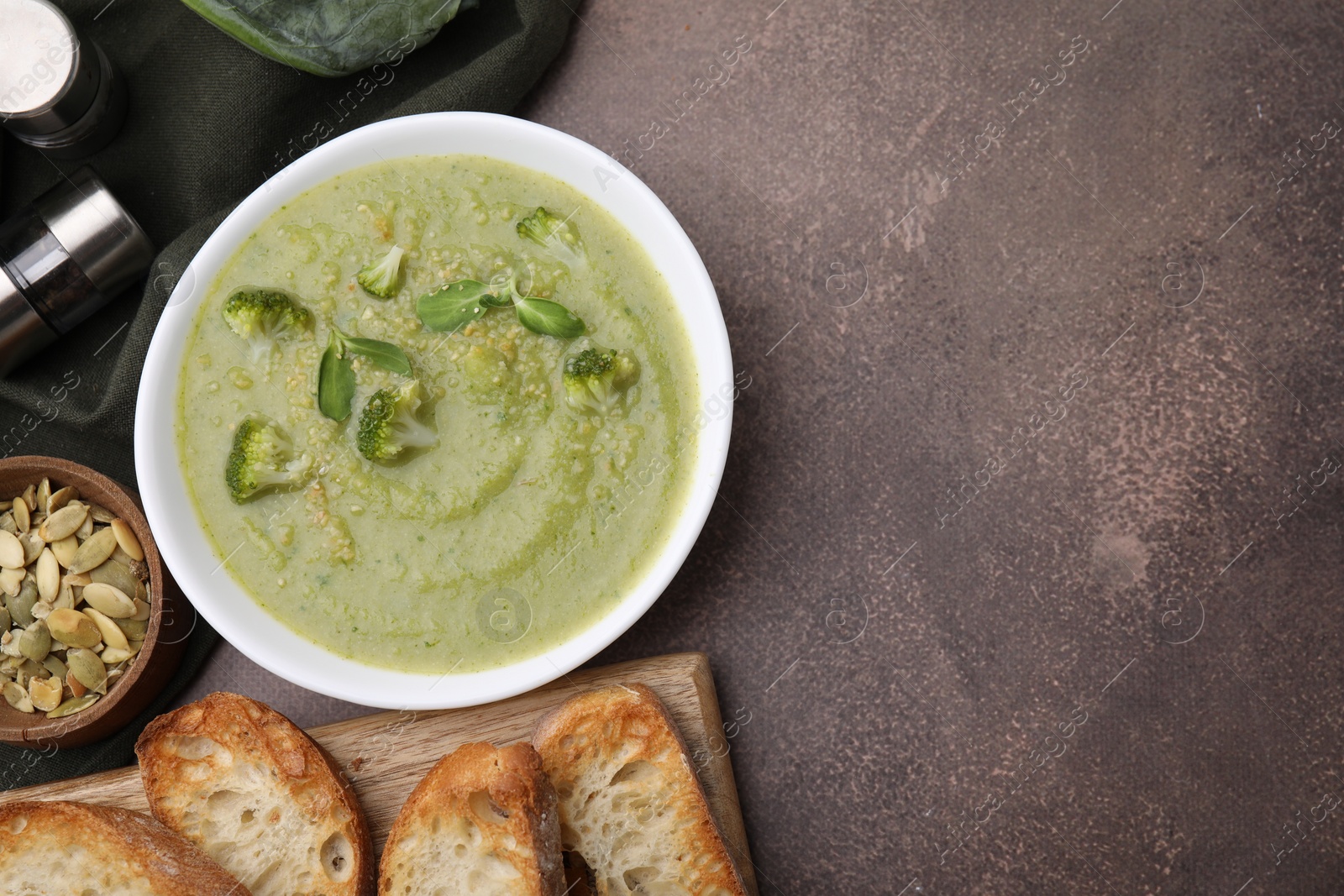 Photo of Delicious broccoli cream soup served on grey table, flat lay. Space for text