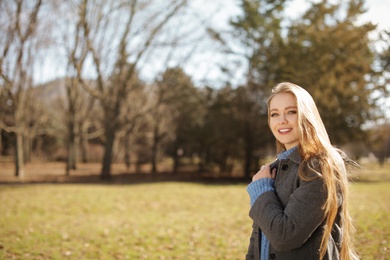 Portrait of beautiful young woman in city park on sunny day