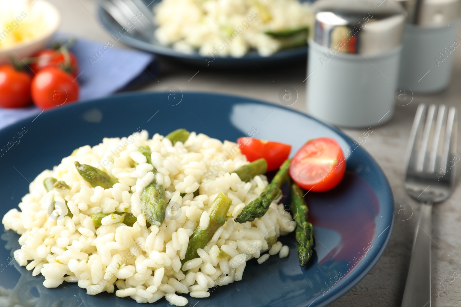 Photo of Delicious risotto with asparagus on plate, closeup