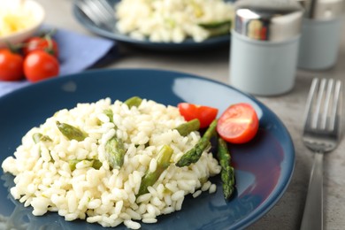 Photo of Delicious risotto with asparagus on plate, closeup