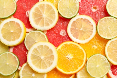 Photo of Different sliced citrus fruits as background, top view