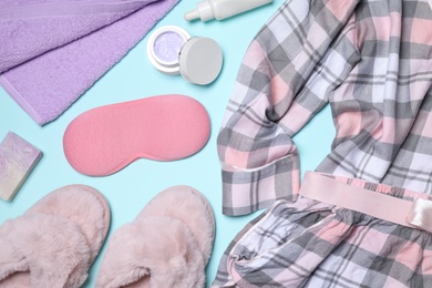 Photo of Flat lay composition with pajamas and accessories on light blue background