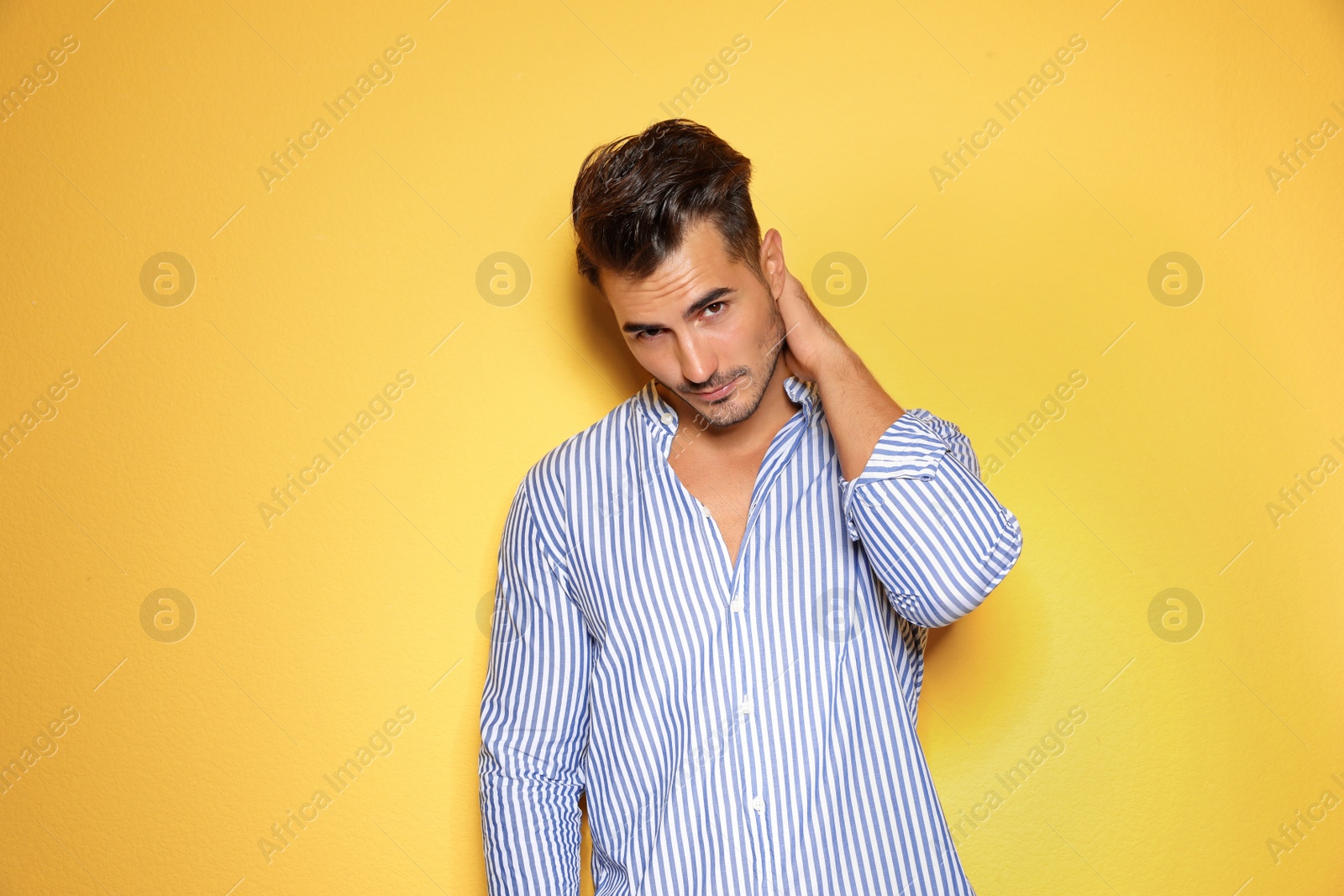 Photo of Young man with trendy hairstyle posing on color background