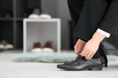 Young man trying on shoes in store