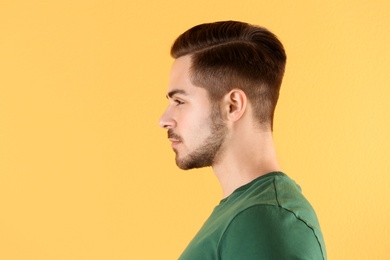 Portrait of young man with beautiful hair on color background