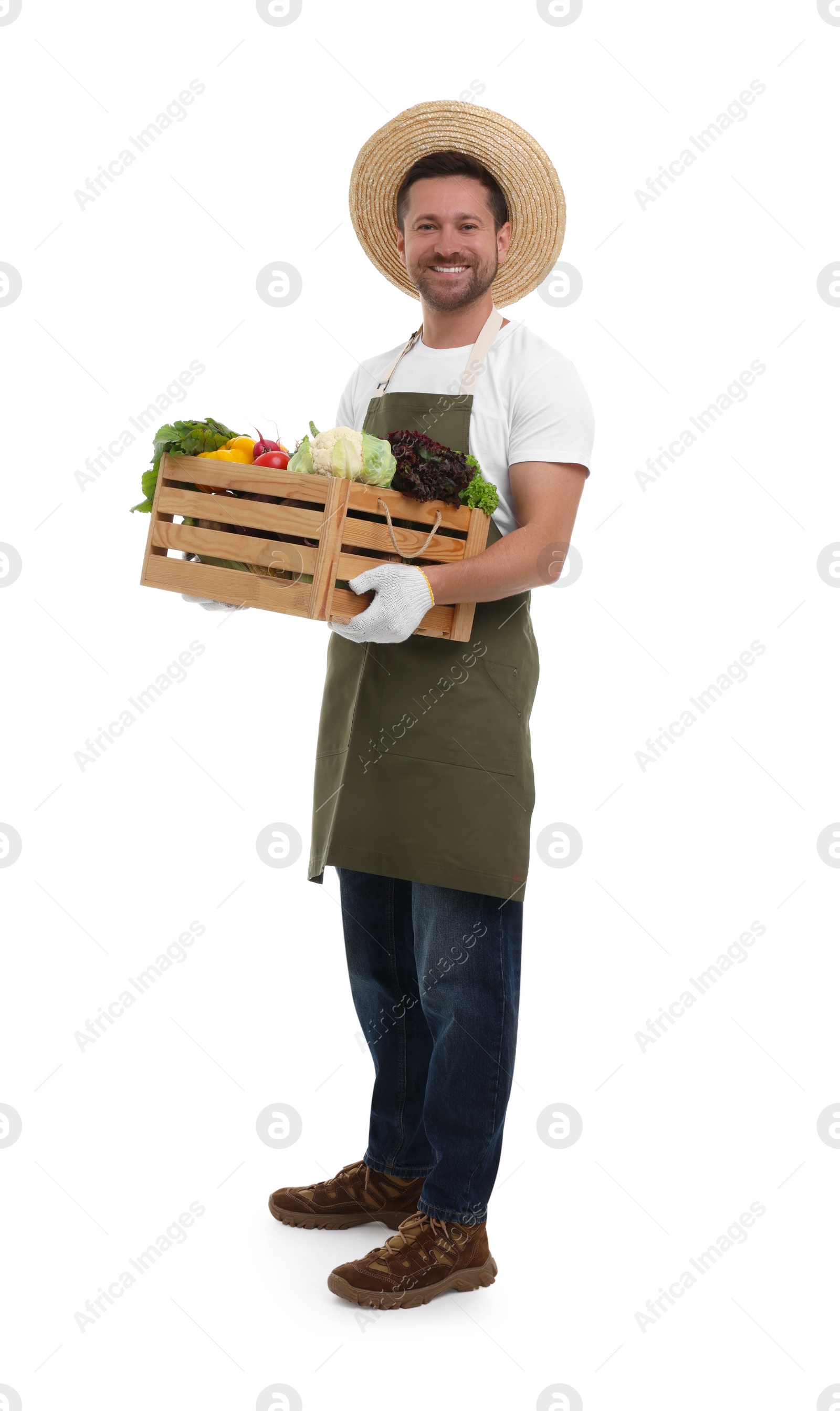 Photo of Harvesting season. Happy farmer holding wooden crate with vegetables on white background