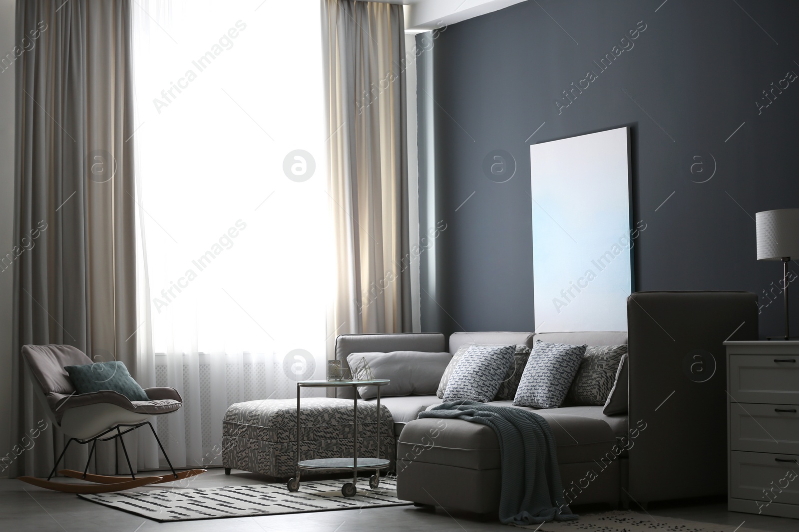 Photo of Comfortable sofa and rocking chair near window with elegant curtains in room