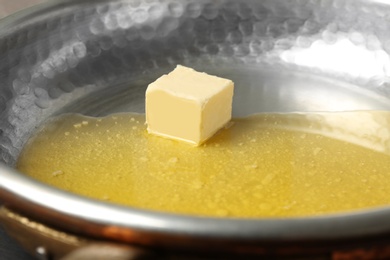 Frying pan with piece of melting butter, closeup