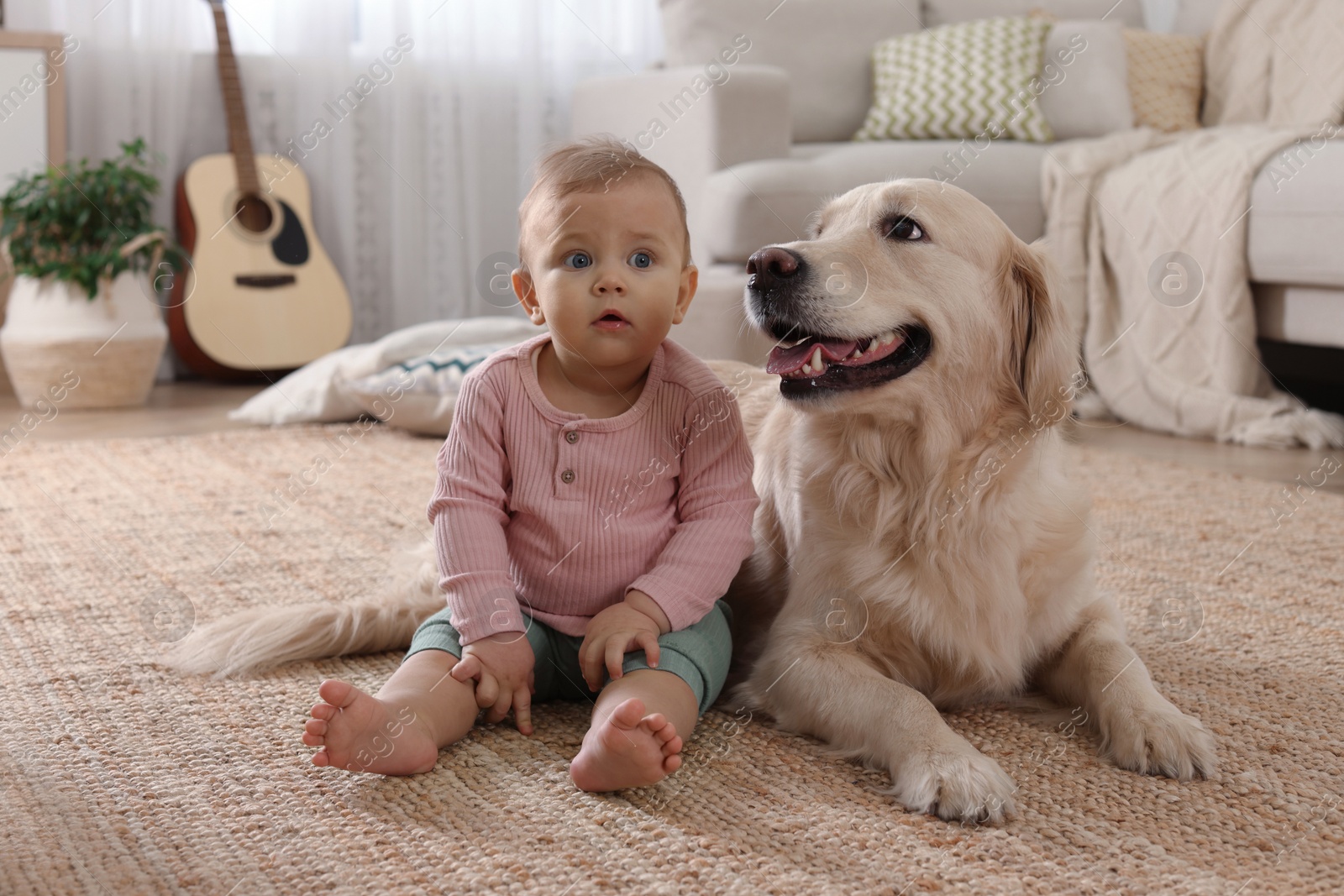 Photo of Cute little baby with adorable dog on floor at home