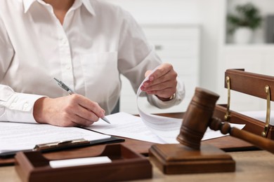 Photo of Lawyer working with documents at wooden table in office, closeup