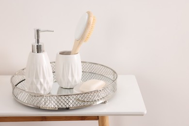 Photo of Different bath accessories and personal care products on table near white wall, space for text