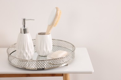 Different bath accessories and personal care products on table near white wall, space for text