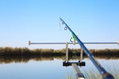 Photo of Fishing rod at riverside on sunny day