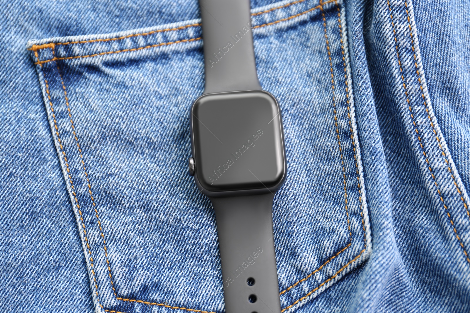 Stylish smart watch on jeans, top view Photo of Stylish smart watch on jeans, top view