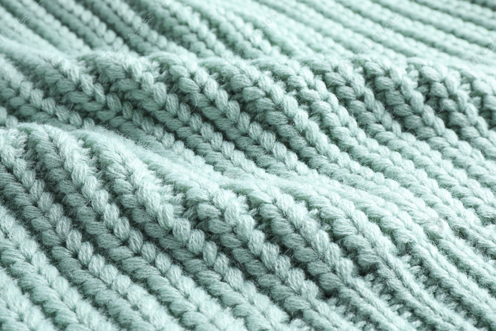 Photo of Warm knitted sweater as background, closeup view