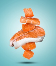 Cut fresh salmon falling on light blue background