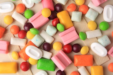 Many different chewing gums on beige background, flat lay