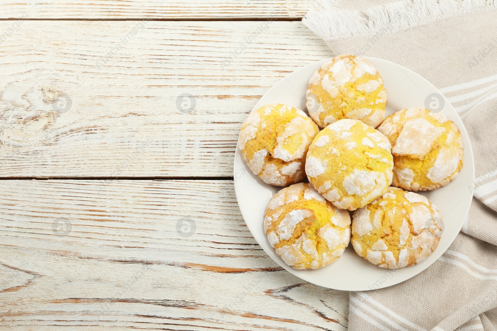 Photo of Tasty homemade lemon cookies on white wooden table, top view. Space for text