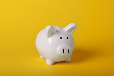 Photo of Ceramic piggy bank on yellow background. Financial savings