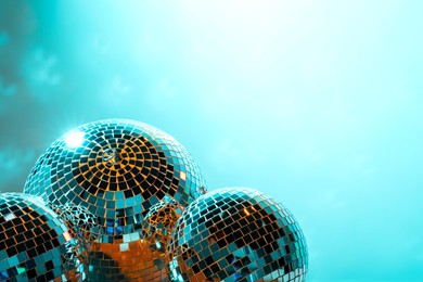 Photo of Shiny disco balls on turquoise background. Space for text